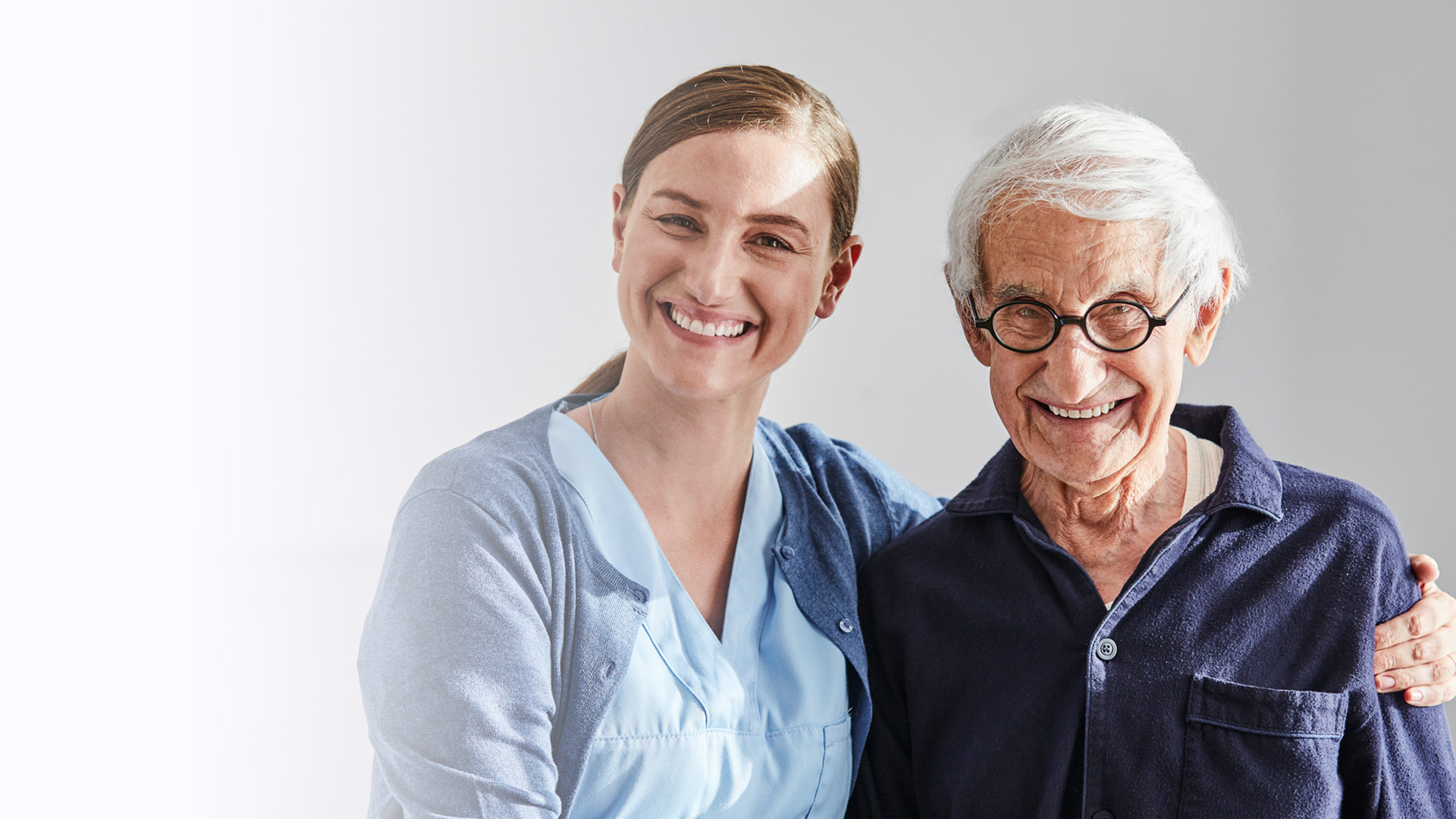 Eine Altenpflegerin von ilomed kümmert sich um einen älteren Menschen