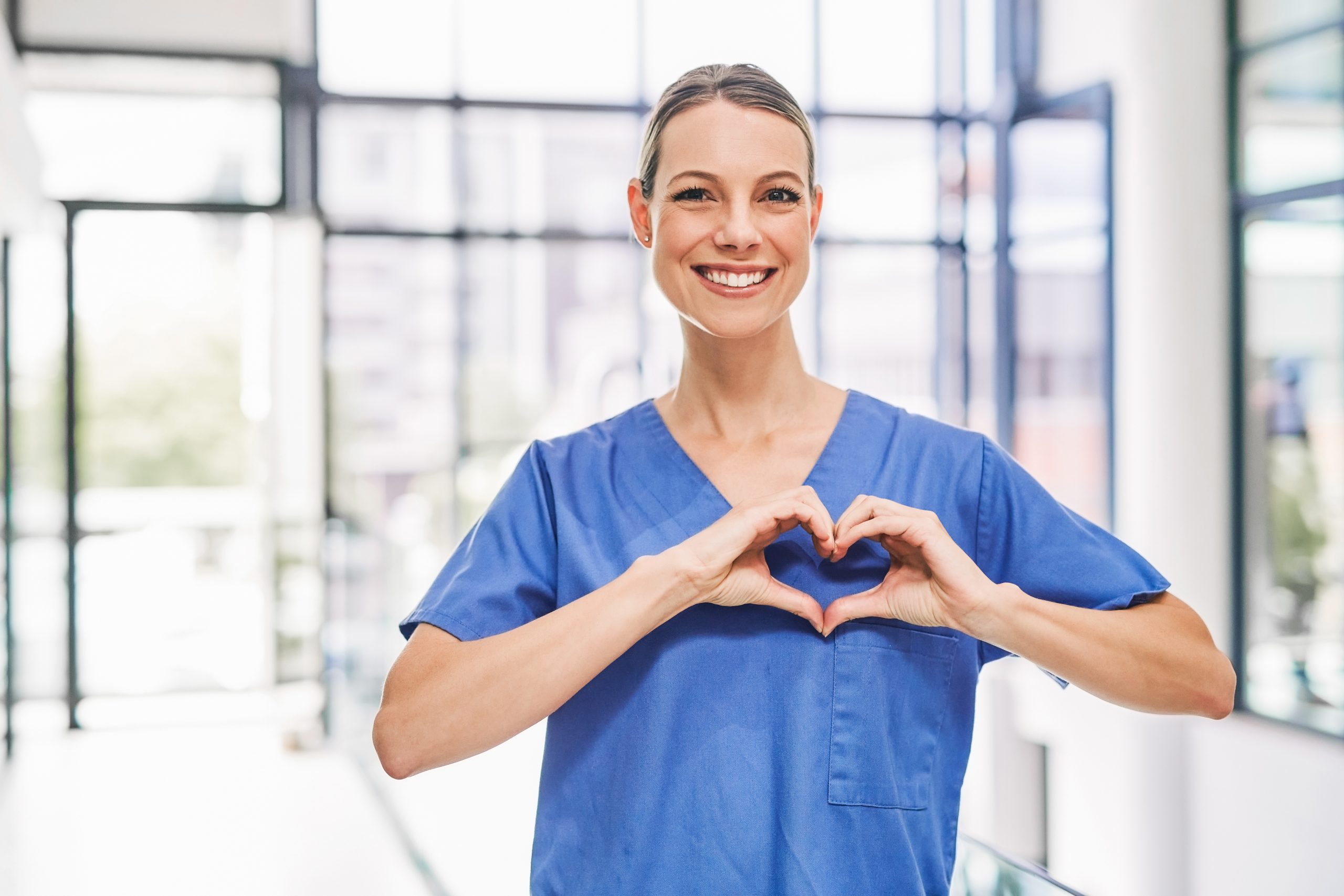 Glückliche ilomed Mitarbeiterin formt mit Ihren Händen ein Herz Glückliche ilomed Mitarbeiterin formt mit Ihren Händen ein Herz